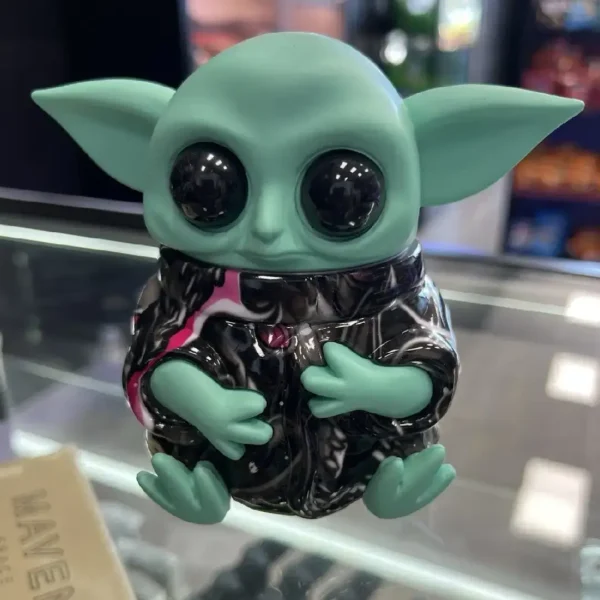Front view of the Grogu Baby Yoda grinder sitting on a glass display counter.