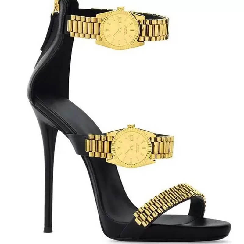 womens golden watch embellished strap sandals studio side profile Side view of a single black high heel sandal featuring three metallic gold watch strap embellishments and a high stiletto heel against a plain white background.